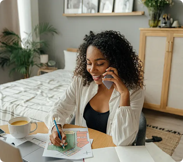 A homeowner on the phone marking up a floor plan